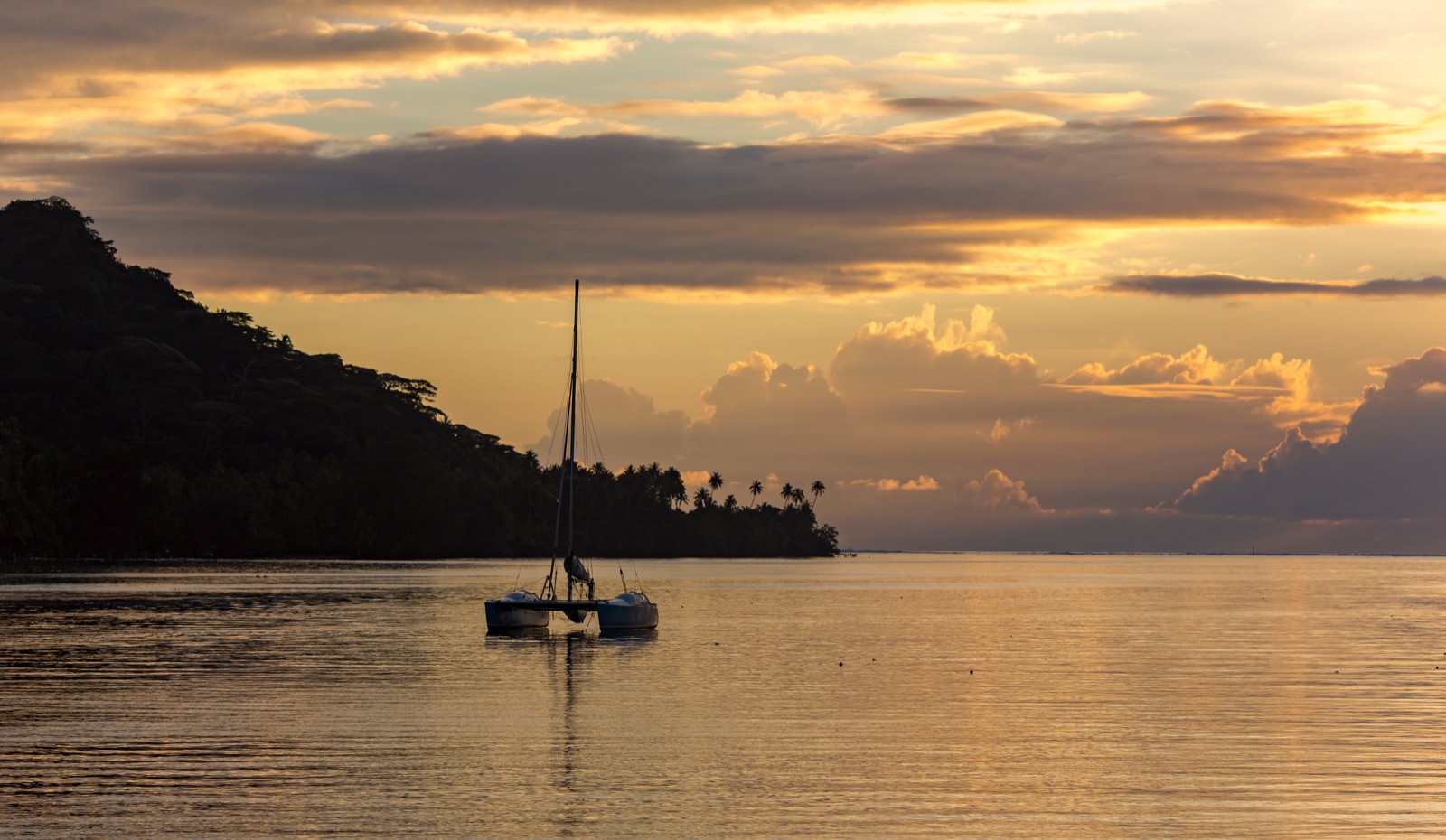 Catamarán fondeado en una laguna al atardecer